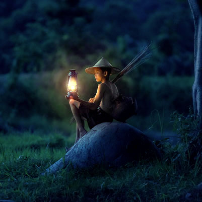 Photographie d'un enfant tenant une lanterne pour s'éclairer pour illustrer le service de référencement naturel de ADN Nations
